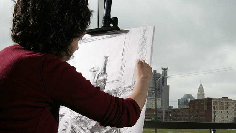 在哥伦布州立大学美术课上画画的女人。
